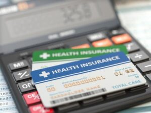 Health insurance card on a calculator