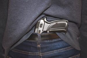 A gun tucked away in a man's pocket.