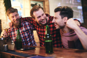 Three men enjoying time together in the pub not knowing they'll be charged with a crime and need a criminal defense attorney