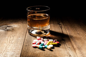 Glass of whiskey and pills on a table
