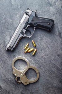 Pistol bullets, handgun and handcuffs.